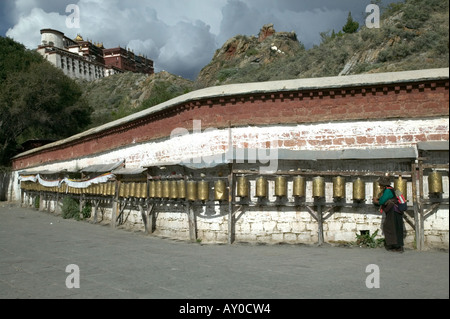 Frau Pilger in traditioneller Kleidung dreht Gebetsmühlen außerhalb der Potala-Palast, Lhasa, Tibet Autonomous Region, China. Am 20. September Stockfoto