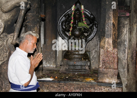 Männliche Verehrer beten vor einem Ganesh Schrein, Meenakshi Tempel, Madurai, Tamil Nadu, Indien Stockfoto