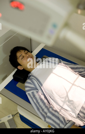 Junger Mann am Röntgentisch liegen Stockfoto