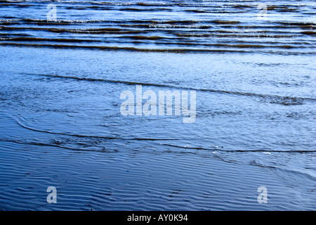 Meer mit Wellen über Sand am Meeresstrand Stockfoto