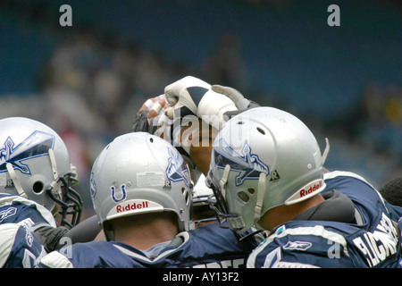 US-amerikanischer American-Football-Spieler beitreten Hände zu Beginn des Spiels Stockfoto