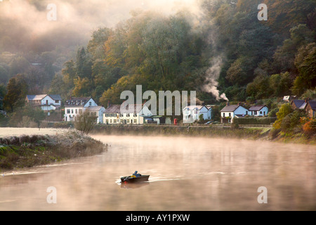 Rauch steigt aus einer Hütte Schornstein auf einem kalten nebligen Dämmerung am Fluss Wye am Dorf Tintern, South Wales Stockfoto