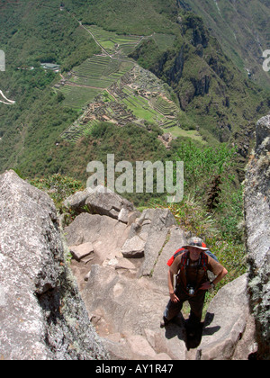 Kletterer aufsteigend den Huayna Picchu Berg mit Blick auf den alten Inka Stadt Machu Picchu die gesehen werden können verteilt unten. Stockfoto