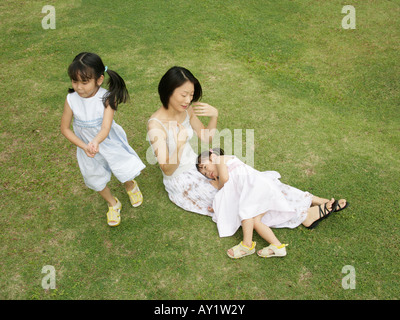 Erhöhte Ansicht der Mutter und ihren beiden Töchtern auf dem Rasen Stockfoto