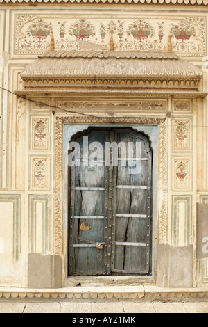 Ein Wetter getragen Tor in einem Haveli in der Stadt Jaipur, Rajasthan, Indien. Stockfoto