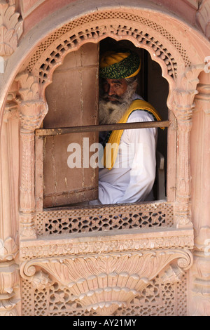 Ein Mann schaut aus dem Fenster im majestätischen Fort in Jodhpur, Rajasthan, Indien. Stockfoto