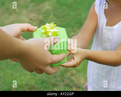 Mid section view of a girl taking a gift from a woman Stockfoto