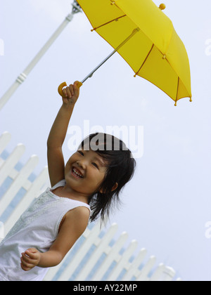 Nahaufnahme eines Mädchens einen Regenschirm halten und Lächeln Stockfoto