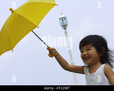 Nahaufnahme eines Mädchens einen Regenschirm halten und Lächeln Stockfoto