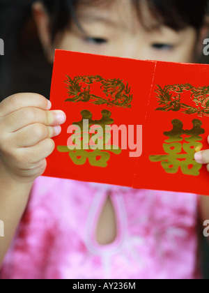 Nahaufnahme eines Mädchens mit roten Geschenk-Pakete (Hong Bao) Stockfoto