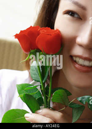Nahaufnahme einer Frau Rosen halten und Lächeln Stockfoto
