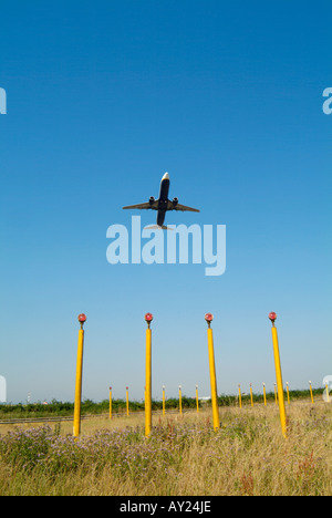 John Lennon Flughafen Landescheinwerfer mit Passagierflugzeug Aufwand abnehmen. Stockfoto