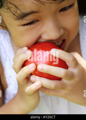 Nahaufnahme eines Mädchens einen Apfel beißen Stockfoto