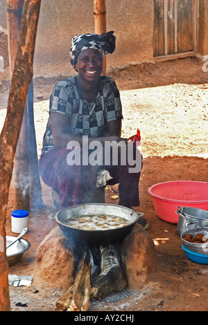 Dorf Frau Essen Anbieter Kochen über Kohlenfeuer in Straße Marktstand in Ghana Westafrika Stockfoto