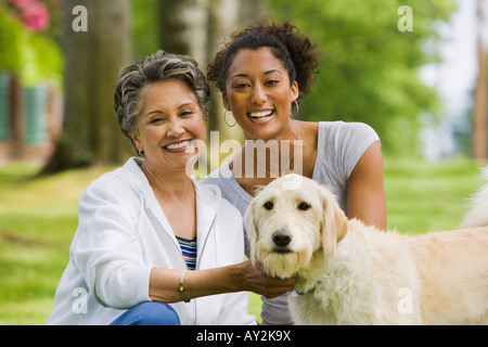 African American Mutter und Erwachsene Tochter Petting Hund Stockfoto