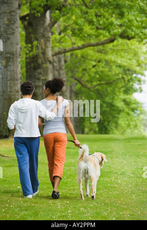 African American Mutter und Erwachsene Tochter walking Hund Stockfoto