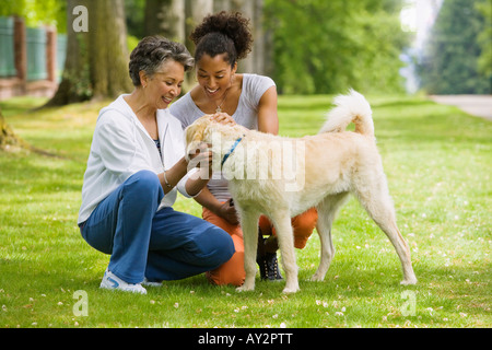 African American Mutter und Erwachsene Tochter Petting Hund Stockfoto