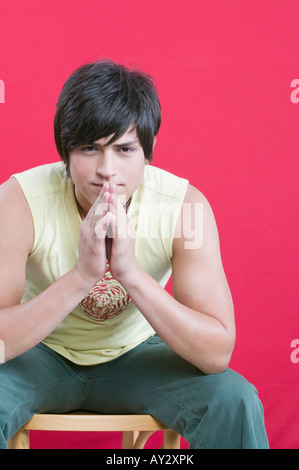 Junge Hispanic Mann sitzt im Stuhl Stockfoto