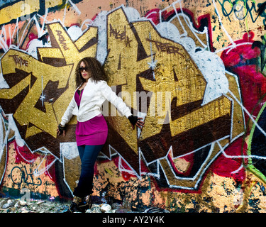 Junge schöne afroamerikanische Frau mit Haltung Röckchen tatenlos bunten Graffiti-Wand Stockfoto