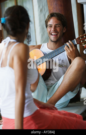 Südamerikanische Mann spielt Gitarre für Freundin Stockfoto