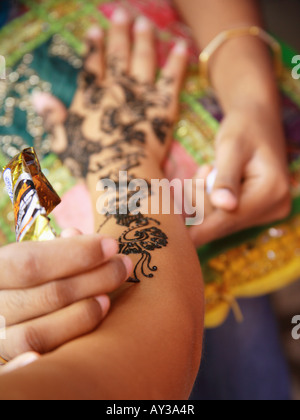 Nahaufnahme der Hand einer Frau, die Anwendung von Henna-Tattoo auf eine andere Frau hand Stockfoto