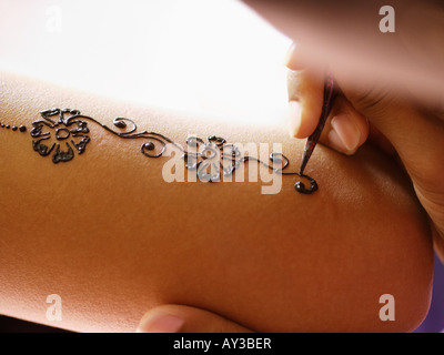 Nahaufnahme der Hand einer Frau, die Anwendung von Henna-Tattoo auf eine andere Person die hand Stockfoto