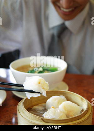 Junger Mann chinesisches Essen mit Stäbchen zu essen Stockfoto