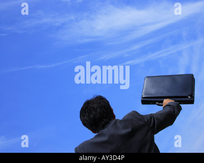 Rückansicht eines Geschäftsmannes holding eine Aktentasche mit erhobenem arm Stockfoto