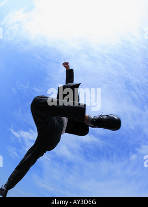 Niedrigen Winkel Ansicht eines Geschäftsmannes springen in der Luft Stockfoto