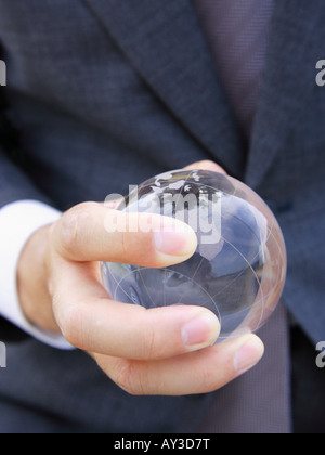Mitte Schnittansicht eines Geschäftsmannes hält eine transparente Kugel Stockfoto