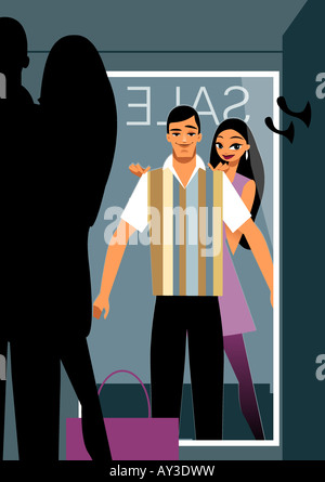 Mann, der versucht auf ein Polo-Shirt vor einem Spiegel in einem Einkaufszentrum Stockfoto