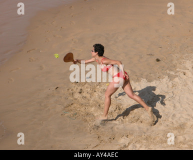 Frau im roten Bikini Beachtennis spielen auf Playa De La Concha San Sebastian Stockfoto