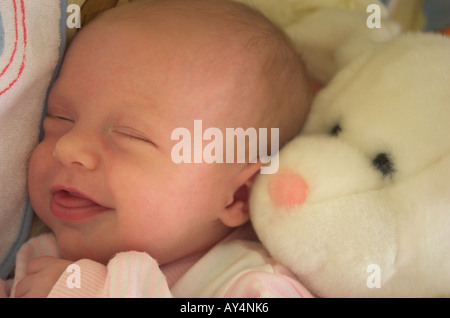 Neugeborenes Babymädchen 0-3 Monate lächelnd, während sie schläft, Großaufnahme eines Gesichts Stockfoto
