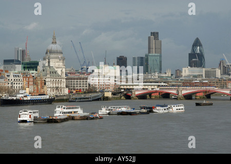 Ansicht der Stadt von London (Quadrat-Meile) über der Themse, mit festgemachten Ausflugsschiffe im Vordergrund, London, England Stockfoto