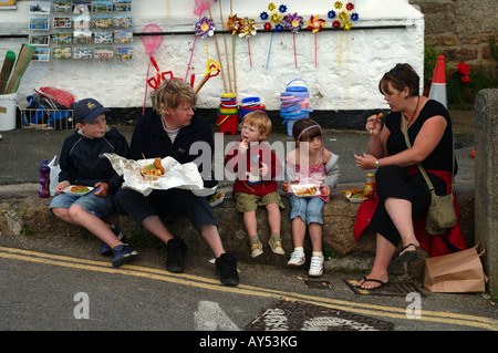 Fish &amp; Chips zu essen, im Dorf Mousehole Cornwall-Familie Stockfoto