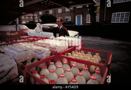 Milchmann Milch in den frühen Morgenstunden in West London von seinem Milchwagen liefern Stockfoto