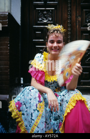 Mädchen saß auf Schritt in Spanische Feria Kleid auf der Málaga-Messe fanning selbst Stockfoto