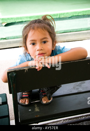 Junges Mädchen sitzt auf einer Bank Neuseeland Stockfoto