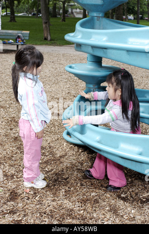Zwei 4 jährige Mädchen reden auf dem Spielplatz Stockfoto