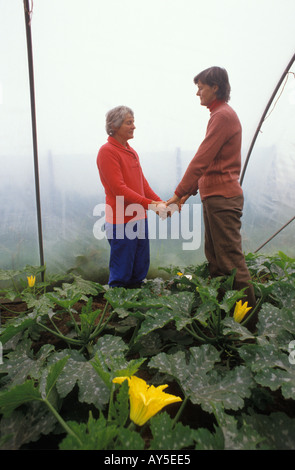 1970er Jahre UK New Age Community. Findhorn Community Foundation Moray Scotland Mitglieder der Gemeinde beten unter Gemüse in einem Gewächshaus. Stockfoto