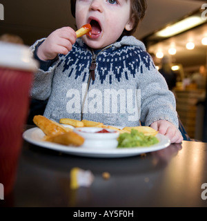 Kleinkind Essen Chips mit Ketchup in einem Café. Stockfoto