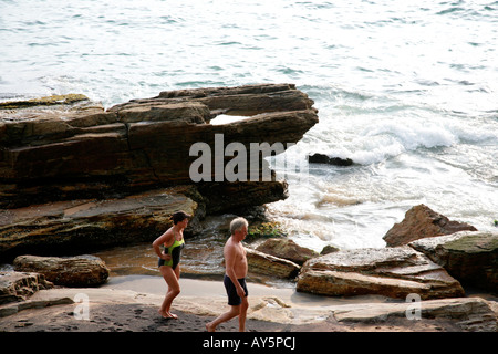 Touristen, die in den felsigen Teil der Strand von Kovalam, Kerala, Indien Stockfoto