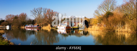 Winterfarben auf dem Fluss Ouse A Cottage mit einem festgemachten Boot entlang der Fluss Ouse Houghton Cambridgeshire England UK Stockfoto