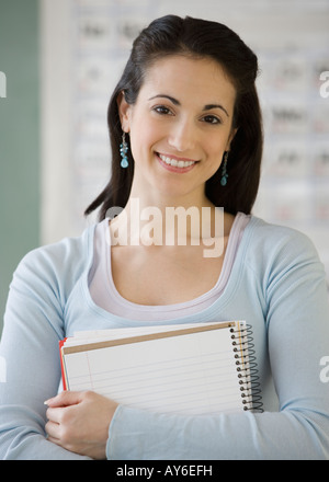 Junge Frau Holding notebook Stockfoto