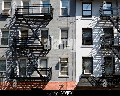 Schwarzes Eisen Feuerleitern auf ältere Wohnung Backsteinbauten in New York City Stockfoto