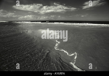 Flut ist hinter einem Sand spucken bringen eine Flutwelle an zwei Punkten am Strand gereist. North Norfolk Stockfoto
