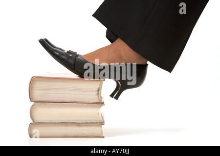 Frau stehend auf einem Stapel Bücher Stockfoto
