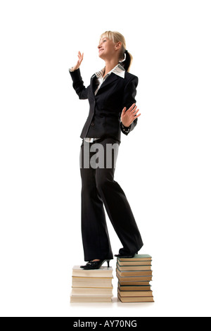 Frau stehend auf einem Stapel Bücher Stockfoto