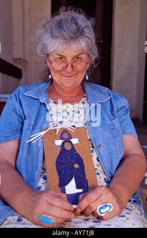 Künstler Cherie Holmes zeigt eine Retablos auf der jährlichen ZOZO Street Fair weiterfahren des Künstlers in Carrizozo, New Mexico. Stockfoto