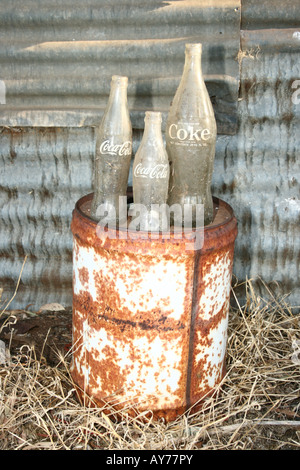 Drei alte Cola-Flaschen stehend auf einem alten Kraftstoff kann Stockfoto